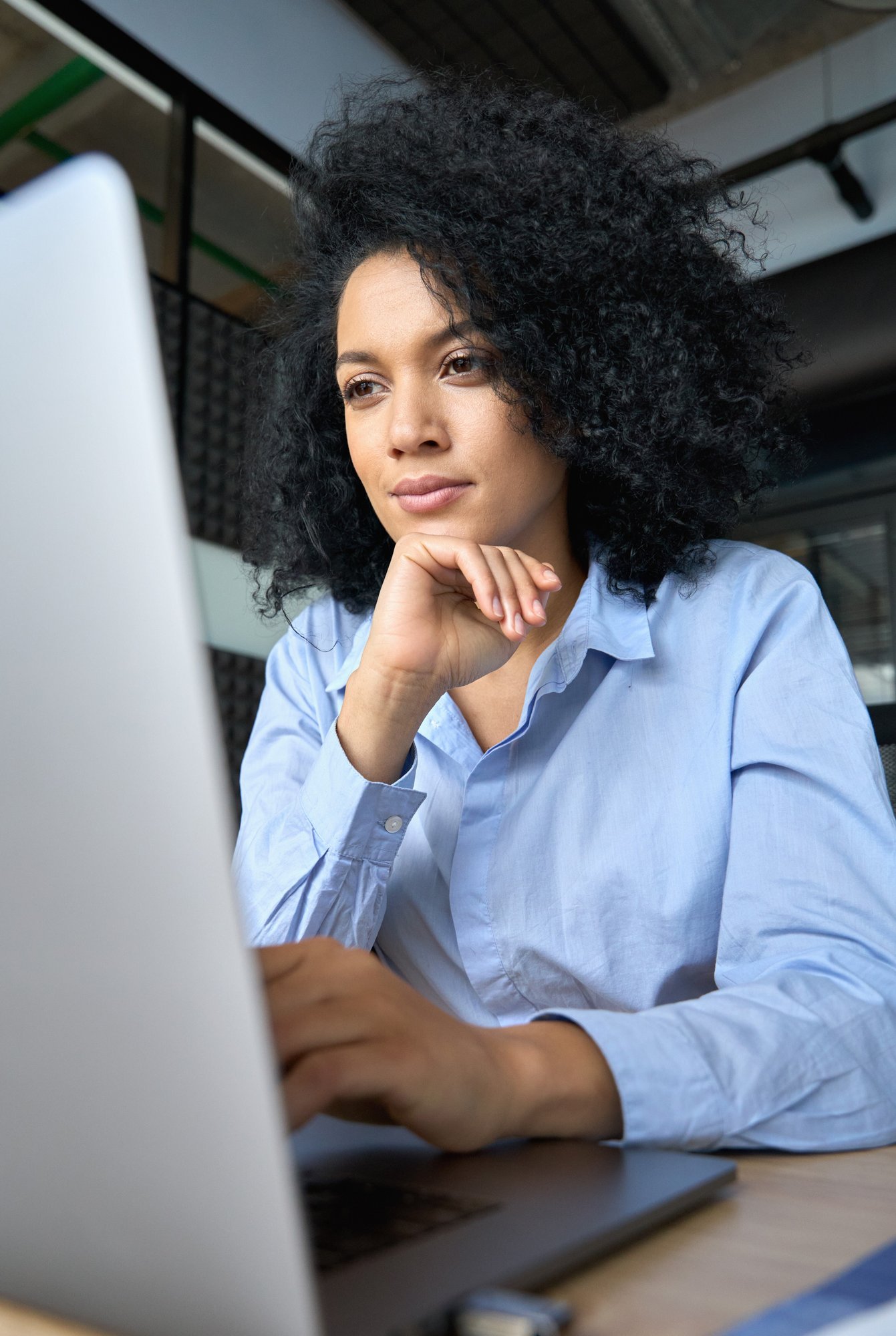 Professional woman working on laptop in modern office environment